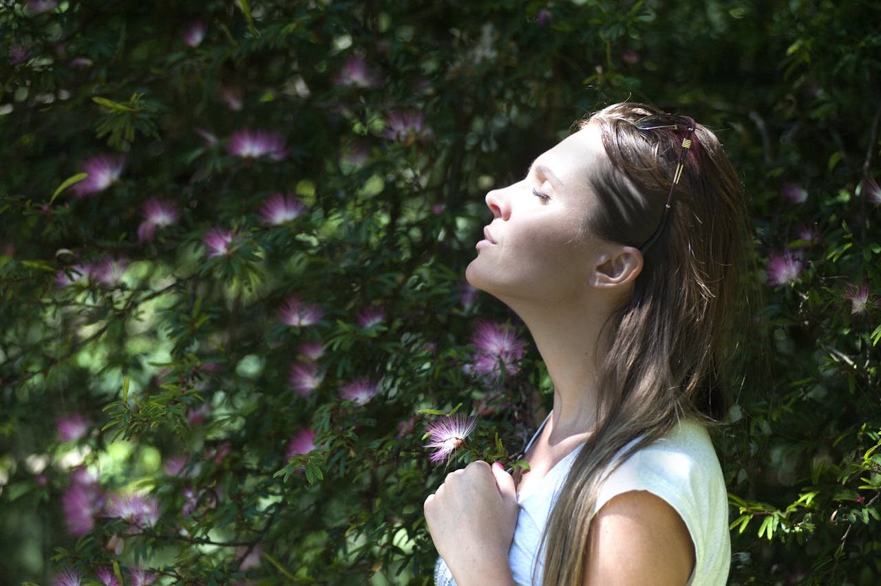 woman looking towards the sun with eyes closed