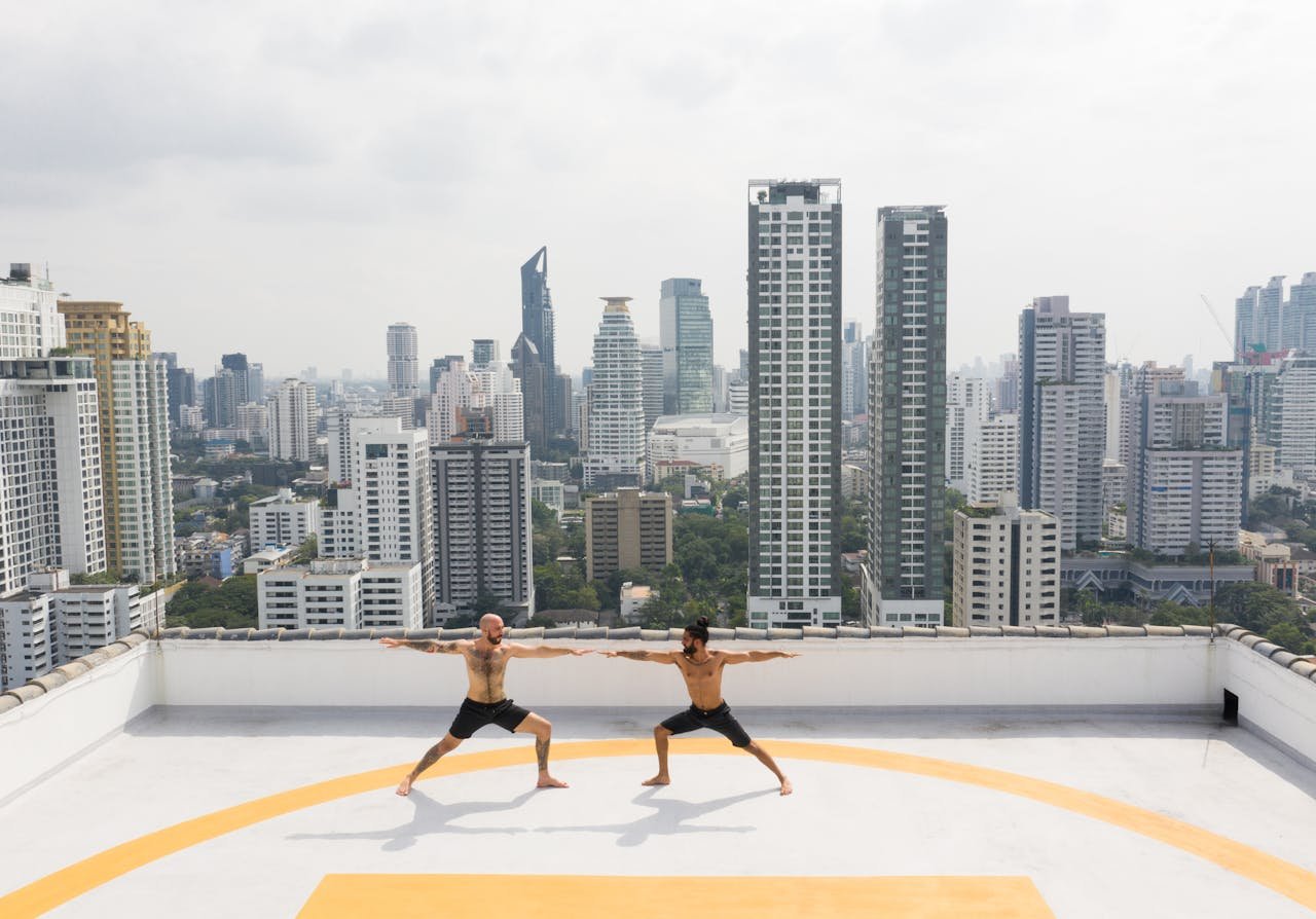 two men doin yoga on rooftop